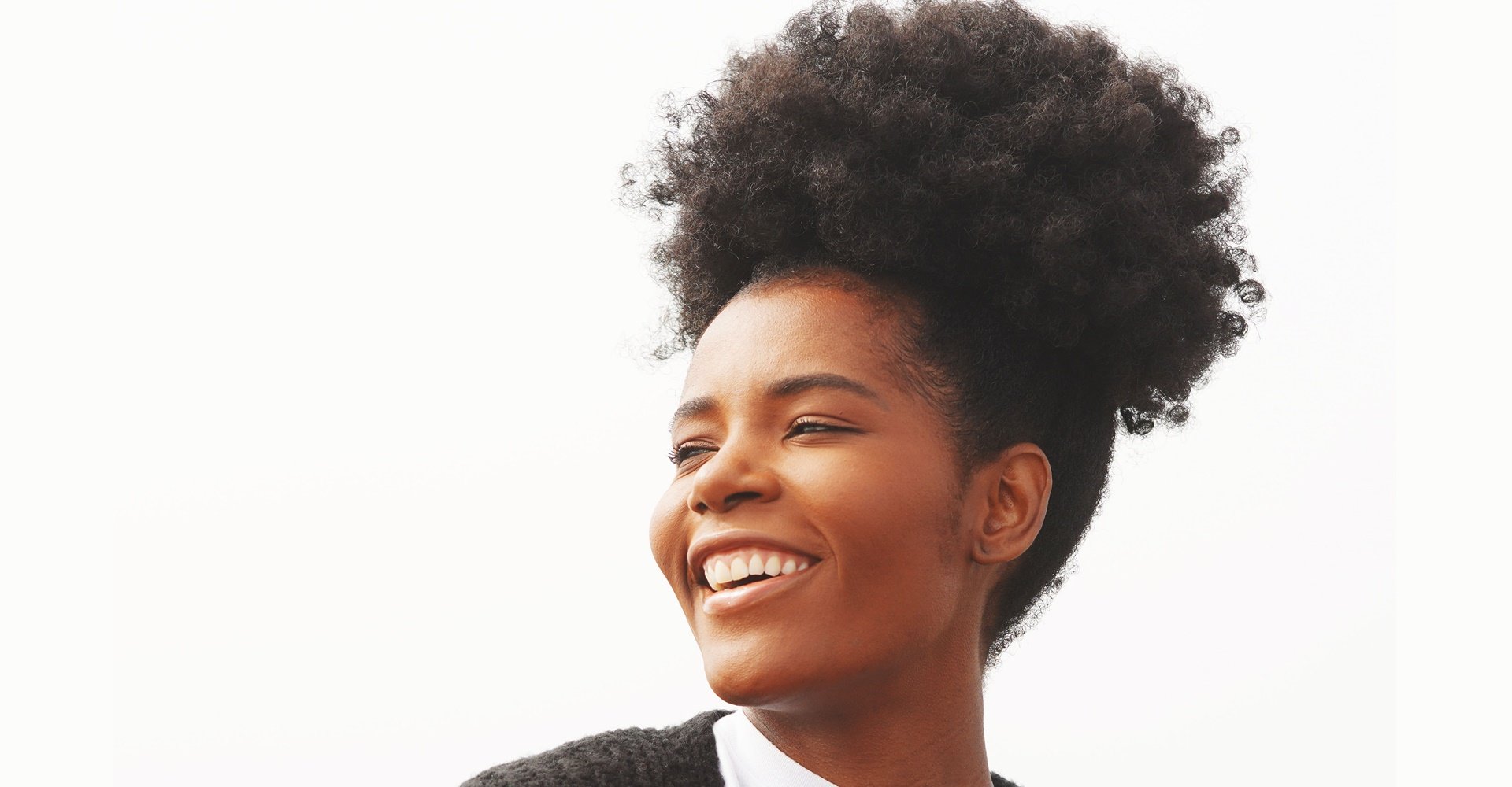 Afro puff com tranças embutidas nas laterais em cabelo cacheado volumoso