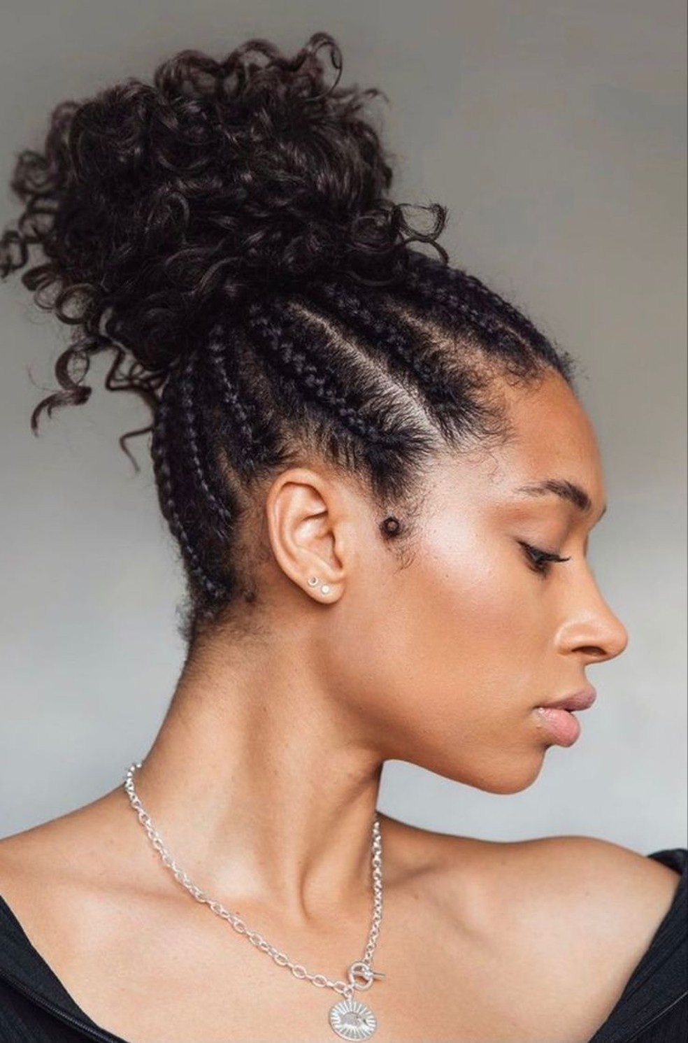 Trança nagô em cabelo cacheado, várias tranças finas rente à raiz em estilo afro