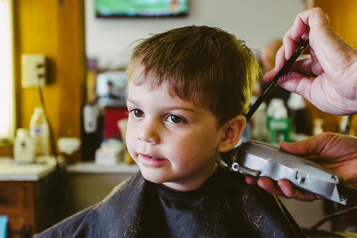 criança pequena no salão durante corte de cabelo infantil rápido