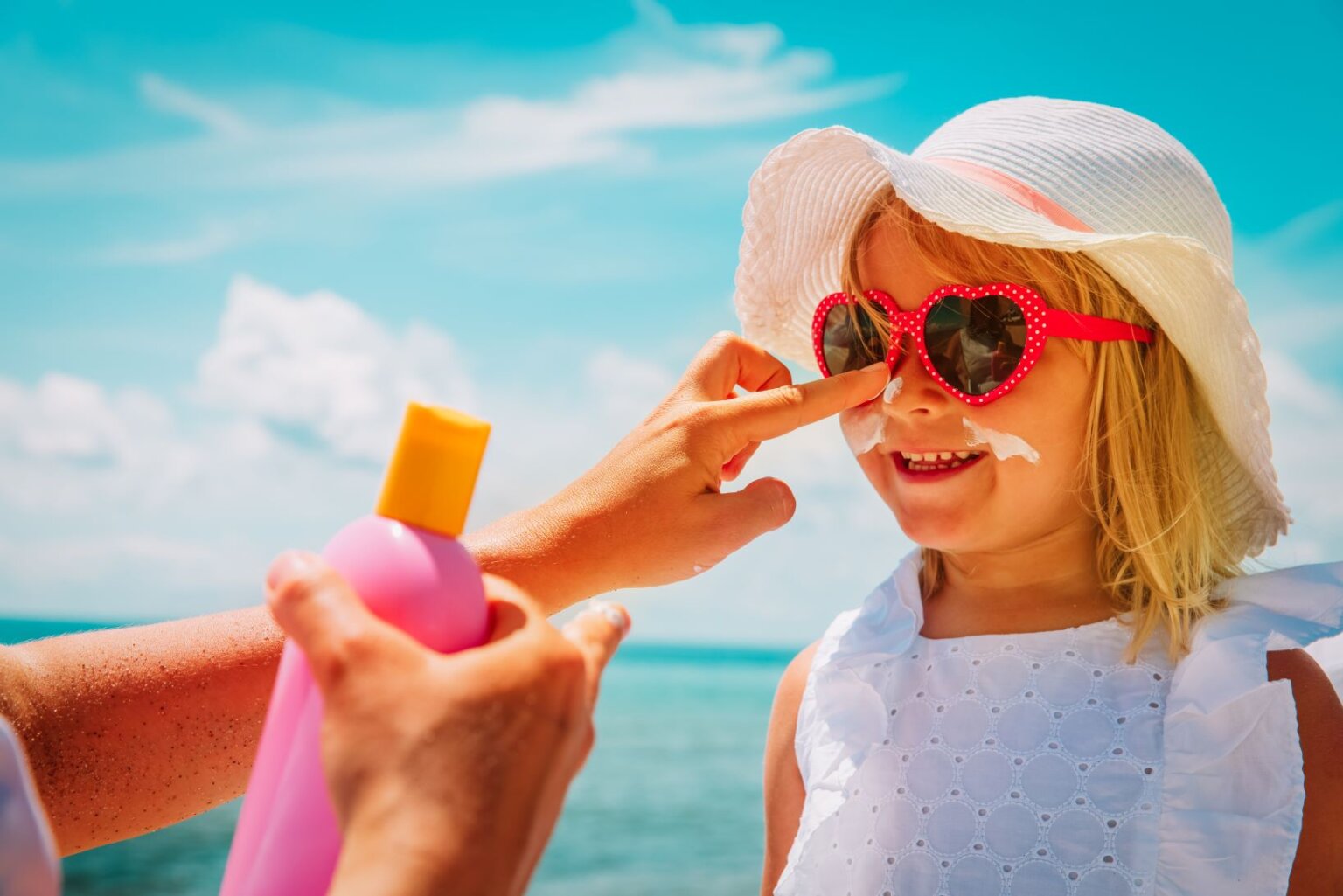 criança de cabelo bem curto usando chapéu para proteger o couro cabeludo do sol