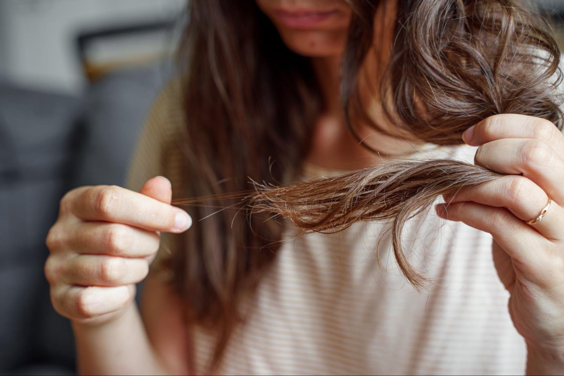 mulher fazendo teste de porosidade capilar com fio no copo d'água — diagnóstico de porosidade antes de escolher produto para cabelo seco