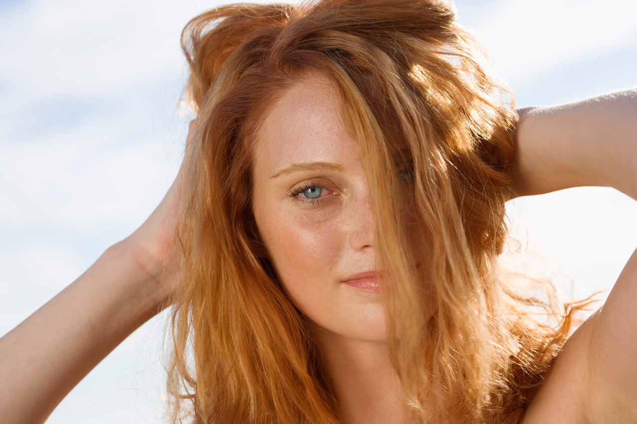 Mulher com cabelo danificado pelo sol e sal na praia