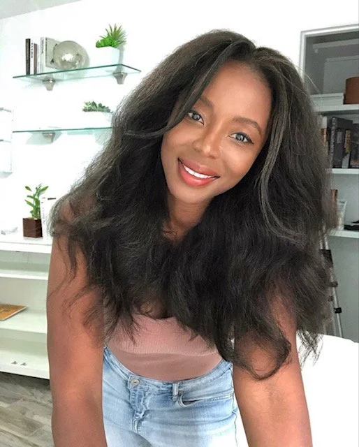 Mulher brasileira tocando o cabelo cacheado com frizz causado pela umidade