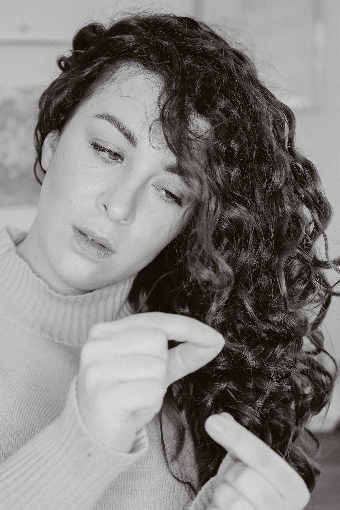 Mulher testando a porosidade do cabelo com um fio em copo de água